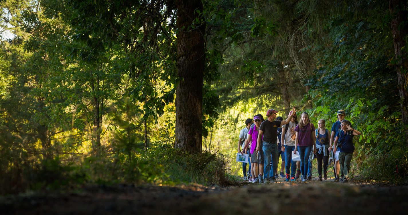 Professor Joe Bowersox leads a group through the woods at Willamette's Zena campus