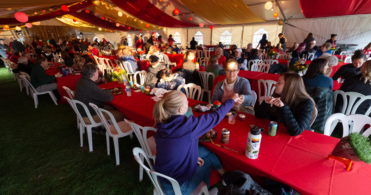 attendees sit under the homecoming tailgate tent