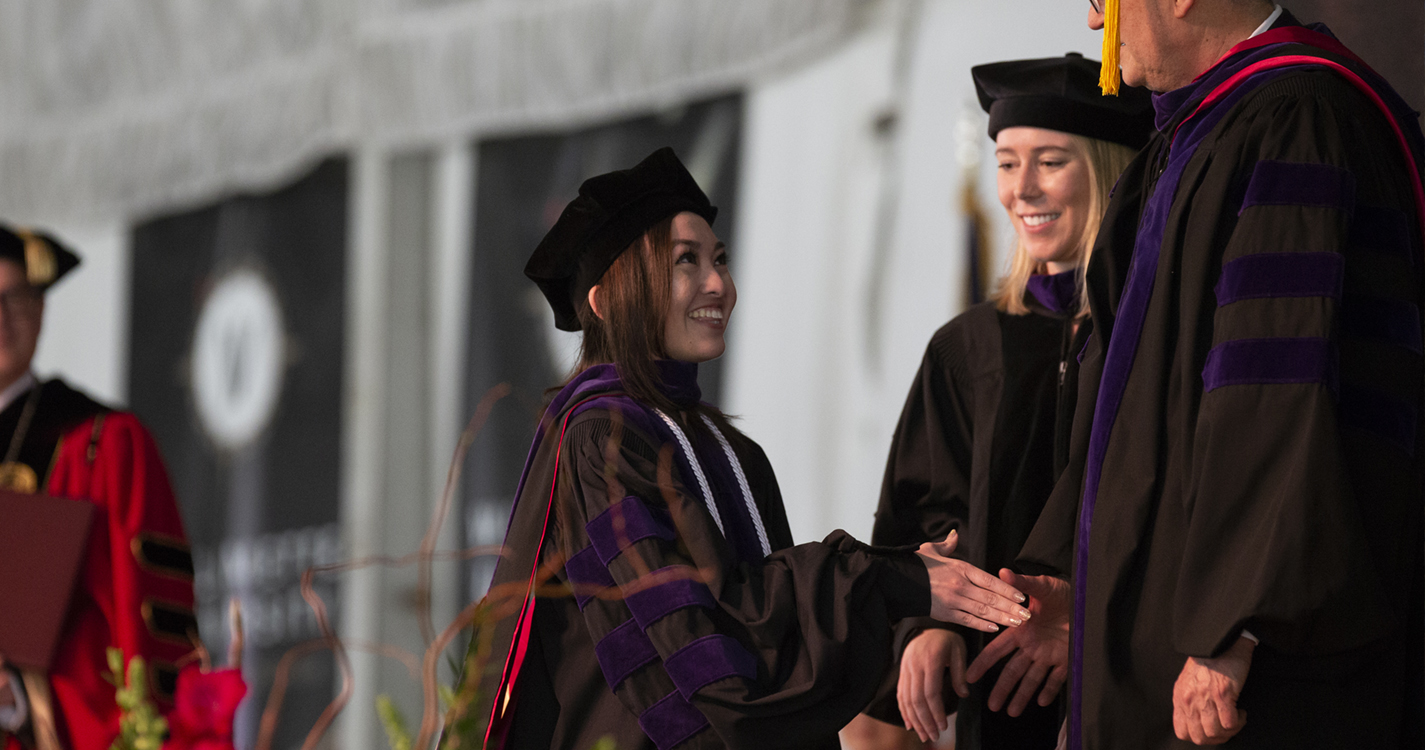 Willamette University College of Law graduate Megan Oshiro receives a diploma at commencement