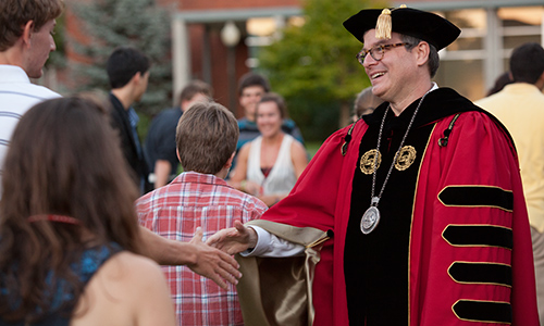 President Thorsett shakes hands and exchanges a few words with first-year students as they gather to participate in the matriculation ceremony.