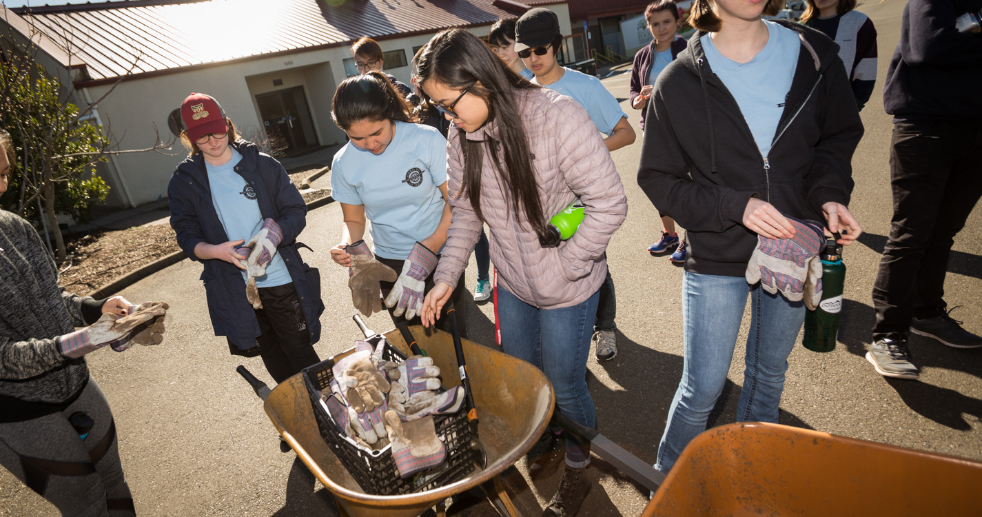 Student put landscaping supplies in a wheelbarrow during Willamette’s Global Day of Service.