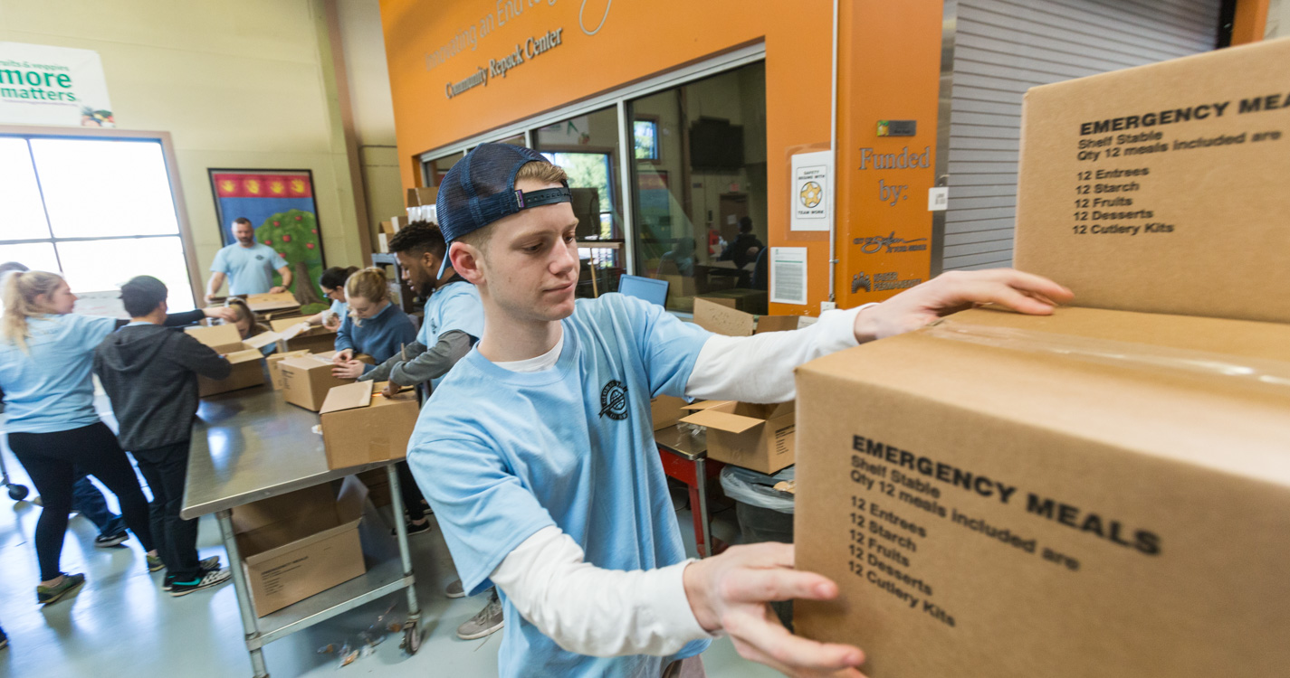 Student packs a box as part of Willamette’s Global Day of Service.