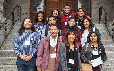Eleven Willamette students stand on the steps of a building at the Pacific Northwest Students of Color Conference at Gonzaga University